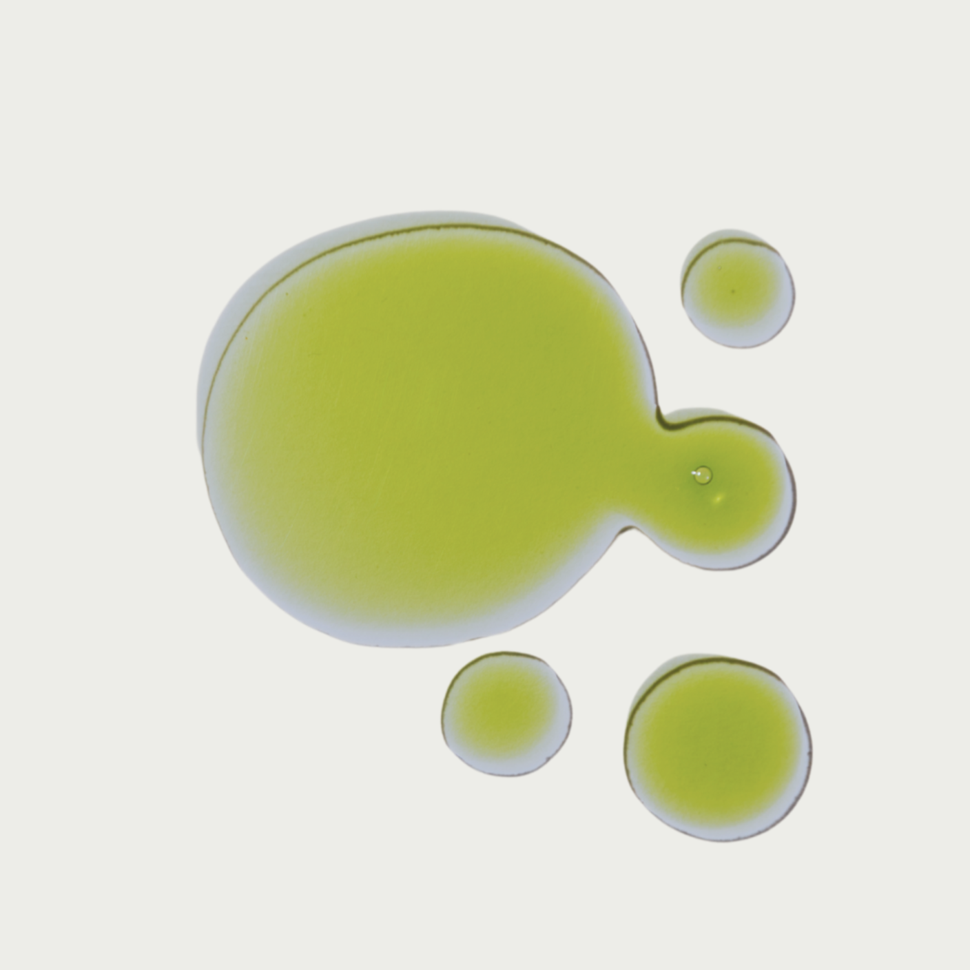 Green facial oil serum on a light gray background