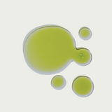 Green facial oil serum on a light gray background