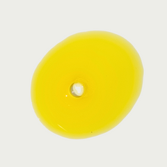 Yellow facial oil serum on a light gray background