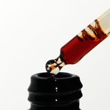 Red Pycnogenol serum in dropper on a white background