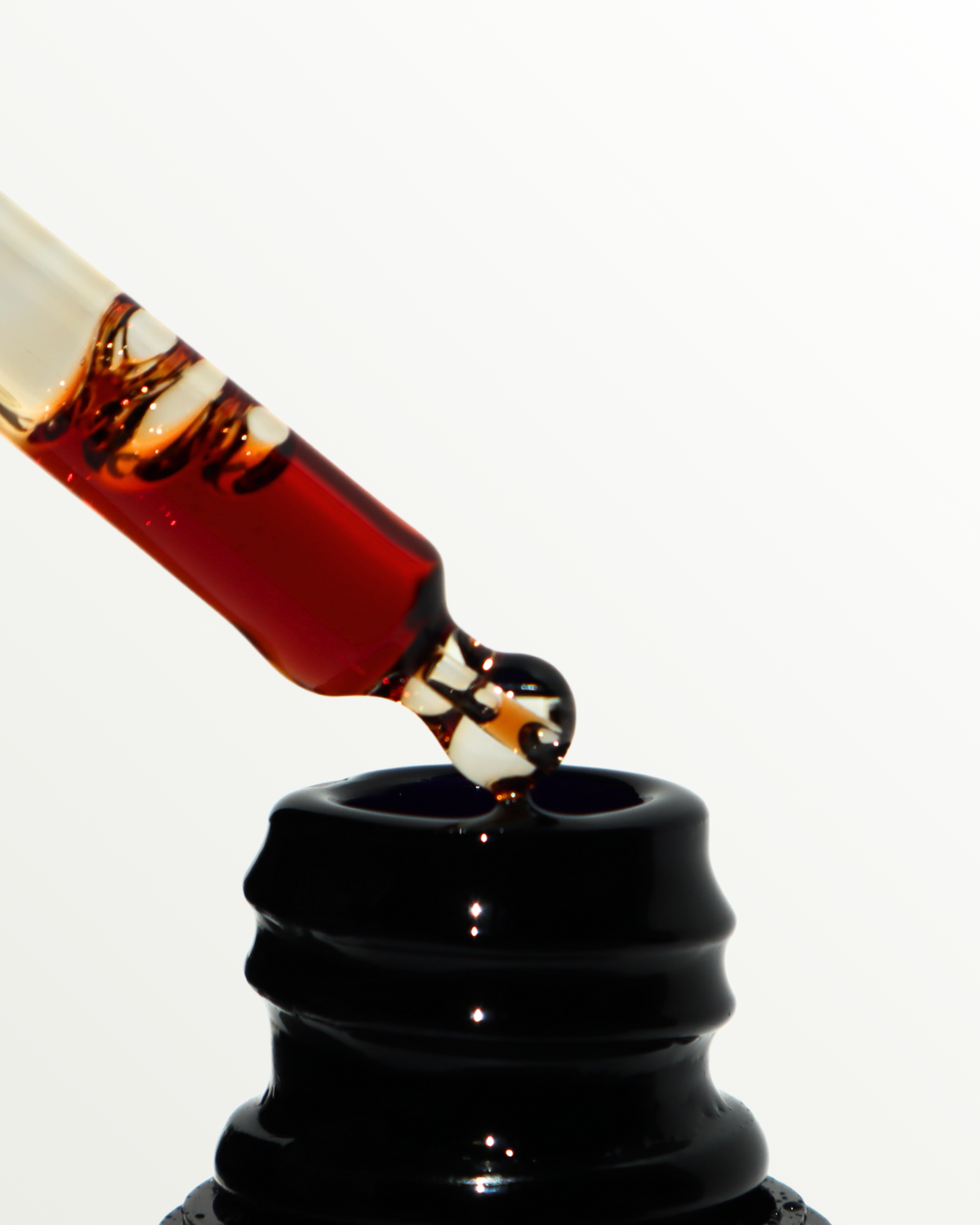 Red Pycnogenol serum in dropper on a white background